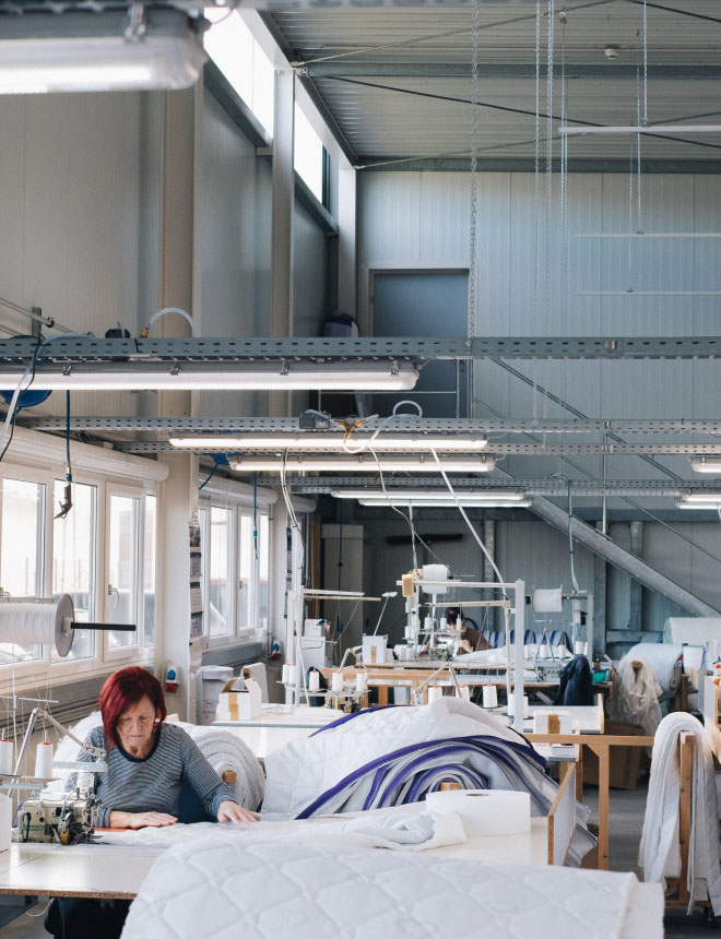 PH-factory-hall-woman-sew@2x